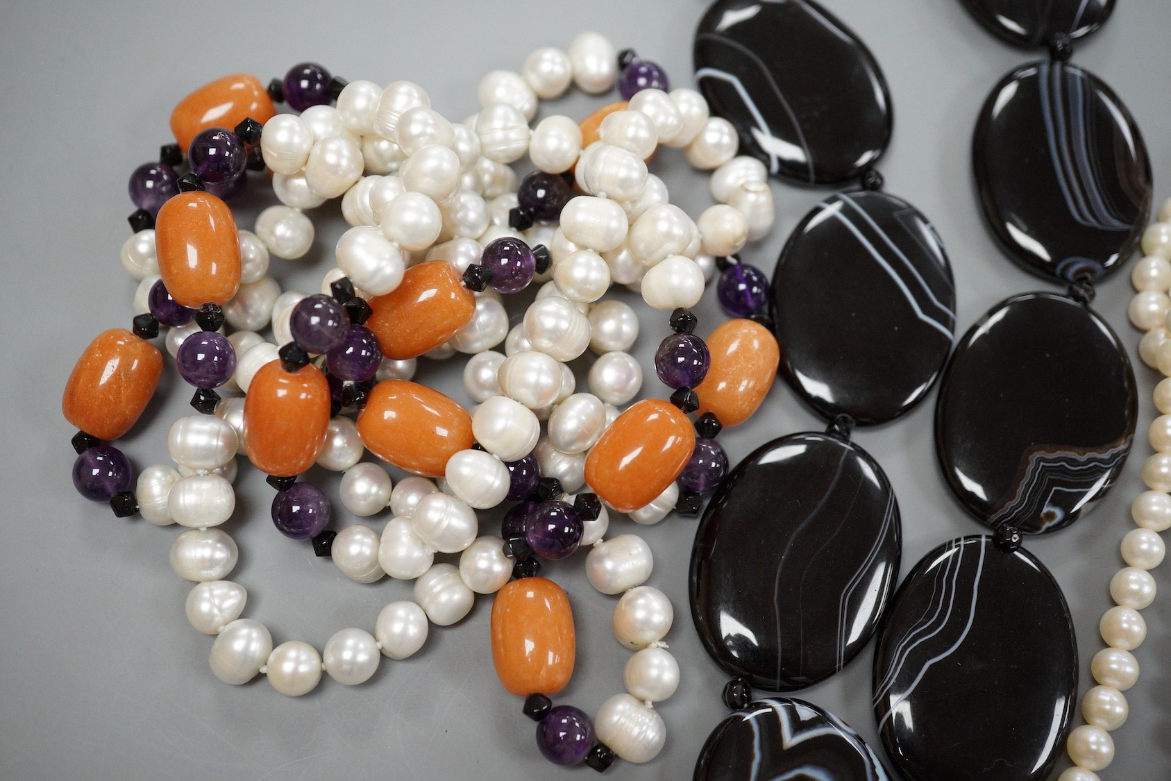 A double strand freshwater pearl necklace, with marcasite set clasp, a banded black agate necklace with 925 clasp and freshwater pearl, amethyst and agate set necklace.